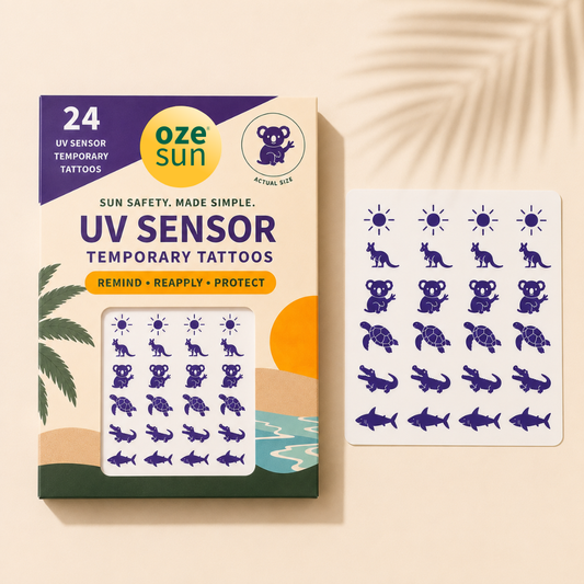 Oze Sun UV Sensor Temporary Tattoos packaging shown next to a sheet of the purple UV-reactive temporary tattoos, including animals and sun motifs, on a beige background with palm leaf shadows.